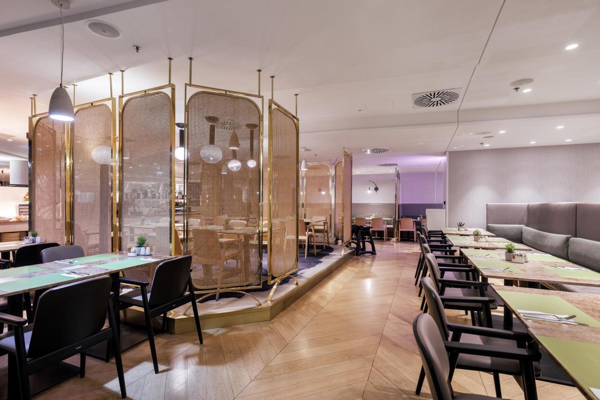 Radisson Blu Resort ชวีโนวิชแจ ภายนอก รูปภาพ The photo depicts a modern restaurant interior. It features a layout with several tables and chairs arranged in an organized manner. There is a decorative partition made of delicate mesh or fabric, providing some privacy between different dining area