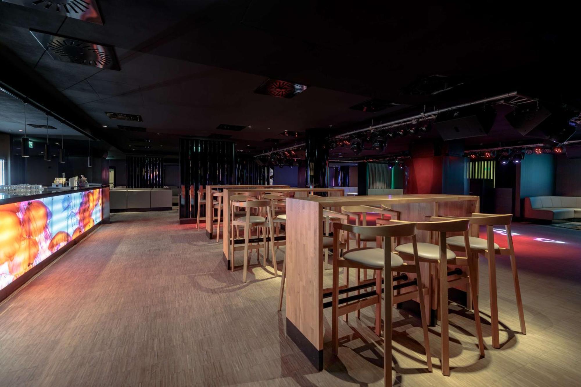 Radisson Blu Resort ชวีโนวิชแจ ภายนอก รูปภาพ The photo shows an interior space that appears to be a bar or lounge. It features a modern design with a dark color scheme. There are several wooden high-top tables with matching stools arranged in the area. In the background, there is a bar counter,