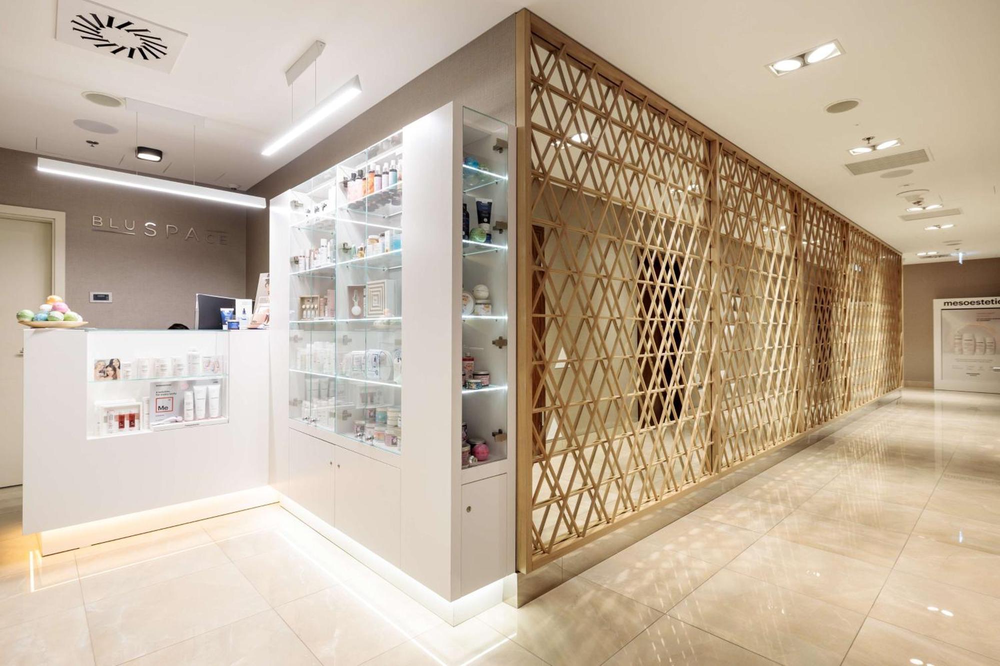 Radisson Blu Resort ชวีโนวิชแจ ภายนอก รูปภาพ The photo shows a modern interior, likely from a spa or skincare clinic. On the left, there is a reception area with a sleek white counter and an illuminated display showcasing various skincare products. The wall behind the reception features a glass