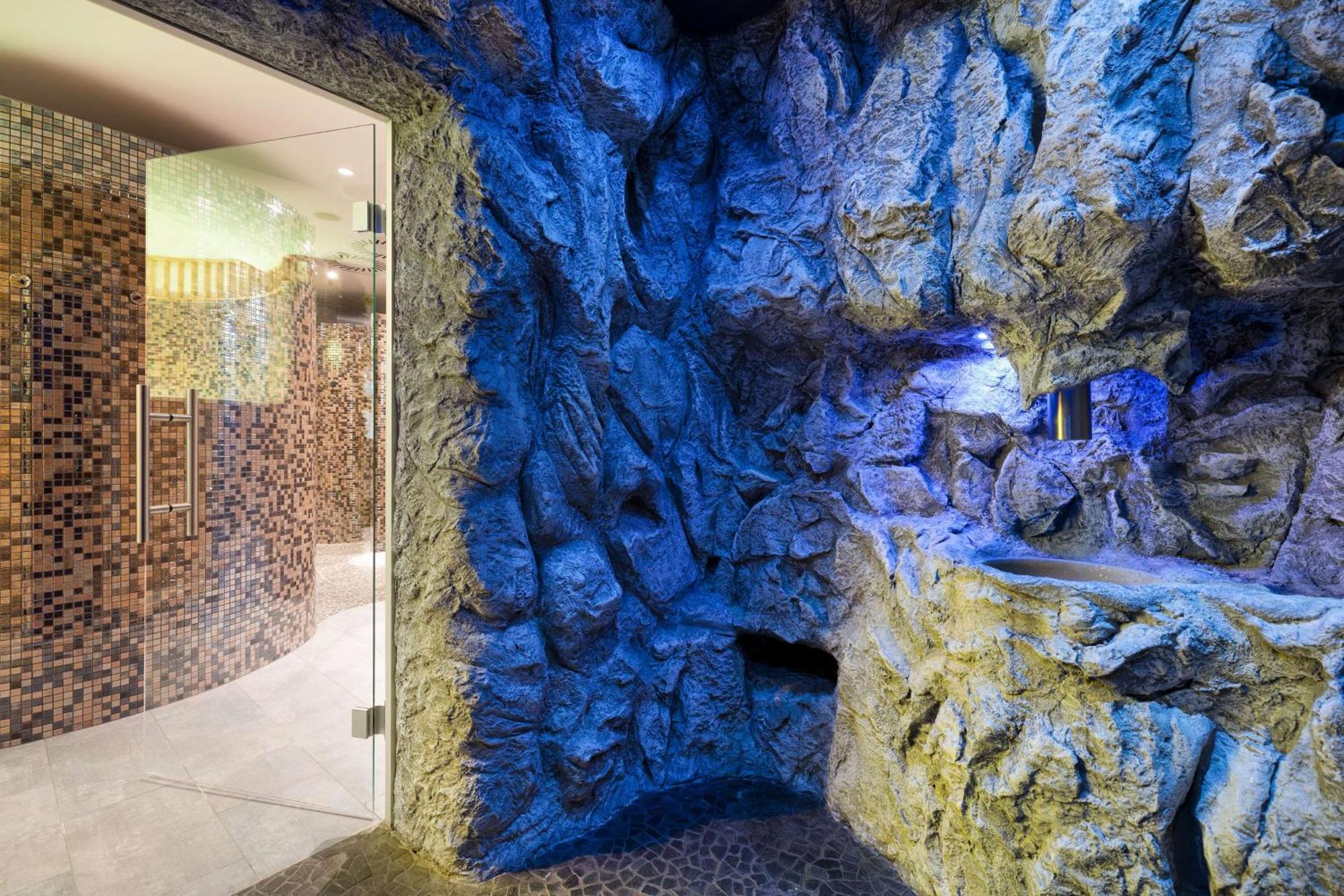 Radisson Blu Resort ชวีโนวิชแจ ภายนอก รูปภาพ The photo shows a spa-like environment with a cave-like design. The walls are styled to resemble natural rock formations, featuring textures and colors that suggest a stone surface. Soft blue lighting highlights the contours of the rocks, creating a 